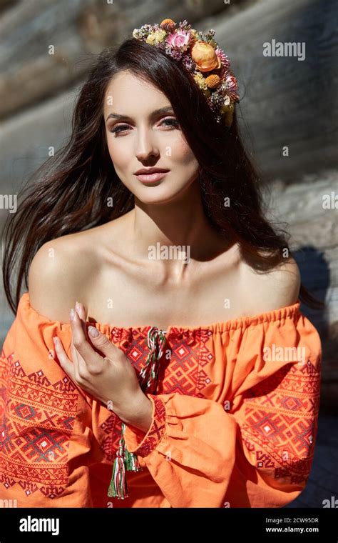 Beautiful Slavic Woman In An Orange Ethnic Dress And A Wreath Of Flowers On Her Head Beautiful