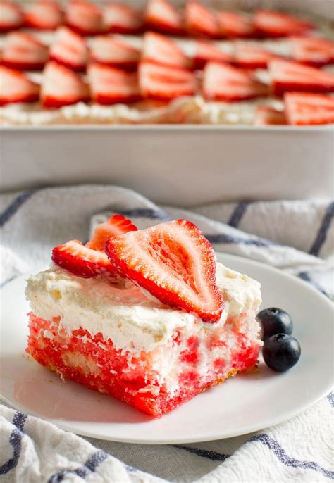 Pouring strawberry jello and cool whip over angel food cake. Strawberry Jello Poke Cake | Culinary Hill