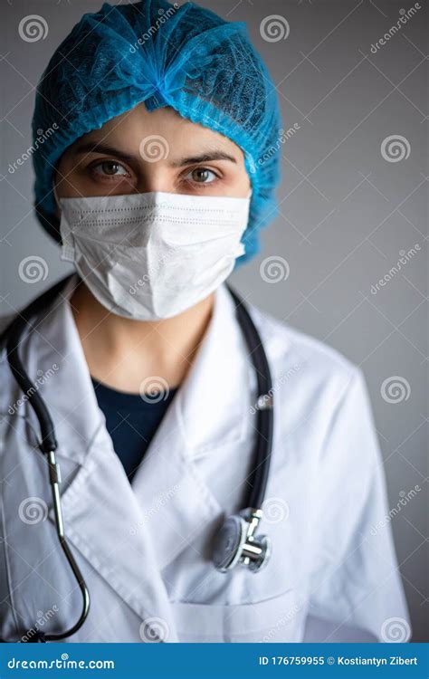 Portrait Of A Young Woman Doctor Wearing White Medical Gown Mask And A