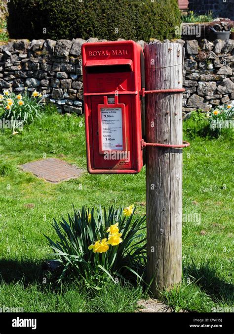 Red Post Box Attached To Wooden Pole In Quaint Village Of Tissington In