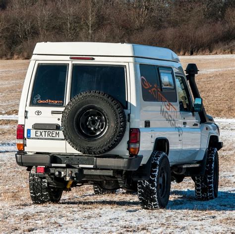 An Off Road Vehicle Parked In The Middle Of A Field With Snow On The Ground