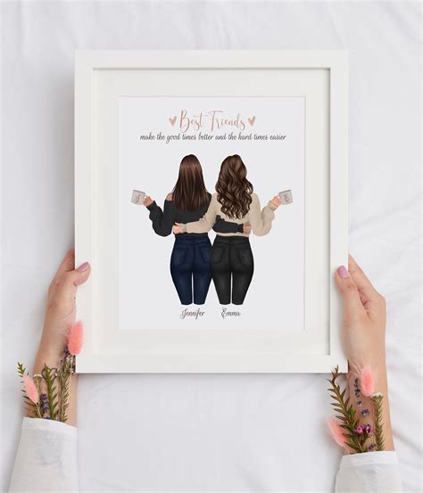 Two Women With Their Arms Around Each Other Holding Up A Framed Print