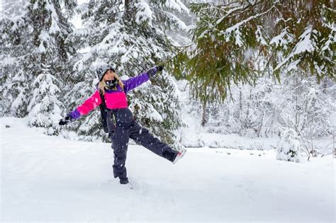 Blonde Young Woman Standing In Snowfall Stock Photo