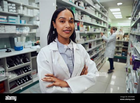 Portrait Of Young African American Pharmacist Standing Between Aisle In