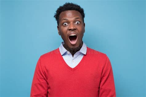 Young African American Man Screaming In Shock Keeping Mouth Wide Open