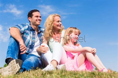 Girl On Dads Lap Sitting On Meadow Or In Field Stock Photo