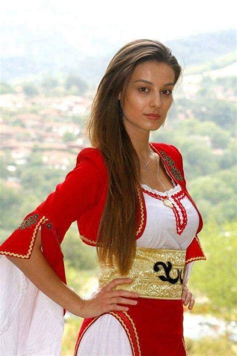 A Beautiful Woman In A Red And White Costume Posing For A Photo With Her Hands On Her Hips