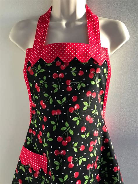 a woman s apron with cherries and polka dots on the front attached to a mannequin
