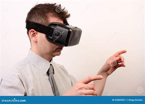 side view of a man wearing a vr virtual reality oculus rift 3d headset touching or pointing at