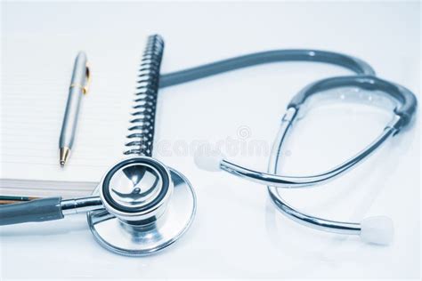 Medical Stethoscope For Doctor Checkup And Notepad On Table Stock Photo
