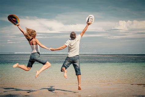 Pares Felices Que Saltan En La Playa Foto De Archivo Imagen De Gente