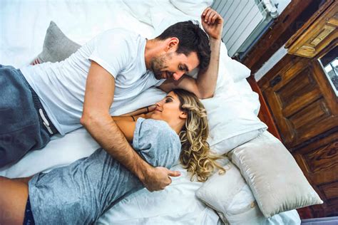 Affectionate Young Couple Cuddling In Bed At Home Stock Photo