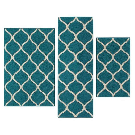 Three Teal Rugs With White And Beige Designs On The Sides One In Front Of