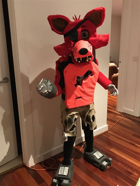 A Person In A Costume Made To Look Like A Fox Standing Next To A Door
