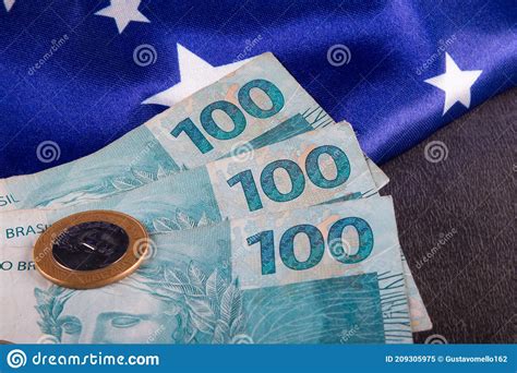 Cem Reais De Notas E Moedas Sobre A Bandeira Brasileira Imagem De Stock