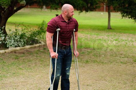 Muscular Bald Man On Crutches Stock Image Colourbox
