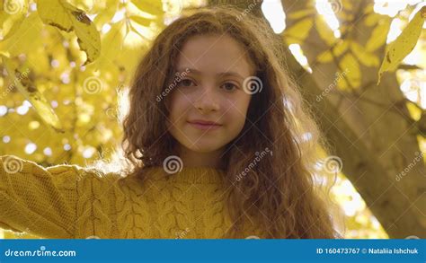 Little Redhead Caucasian Girl Standing In The Autumn Park In Sunrays