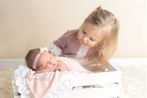 Sisters Big Sister Looks Lovingly At Her Newborn Baby Sister