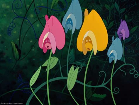 Three Colorful Flowers With Faces On Them In Front Of A Dark Green