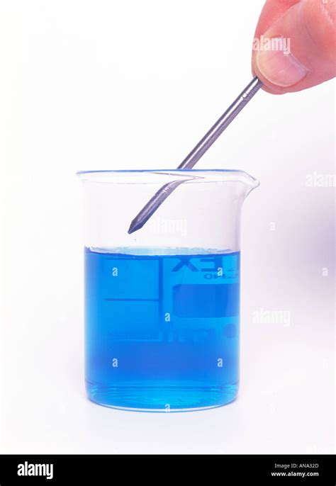 An Iron Nail About To Be Put Into A Beaker Of Copper Sulphate Stock