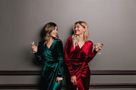 Free Photo Well Dressed Girls Looking At Each Other While Drinking Wine Laughing Friends