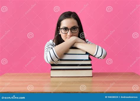 Happy Smiling Female Student Sitting At Her Desk With Textbooks Stock