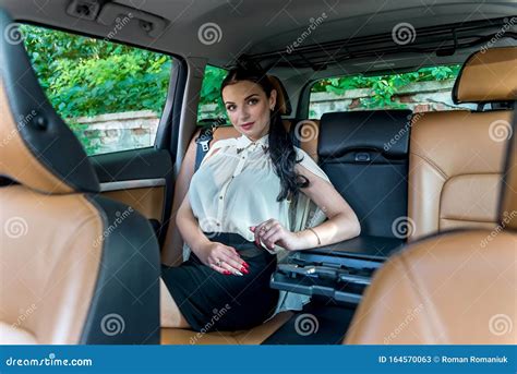 Attractive Businesswoman Sitting On Back Seat Of A Car Stock Image