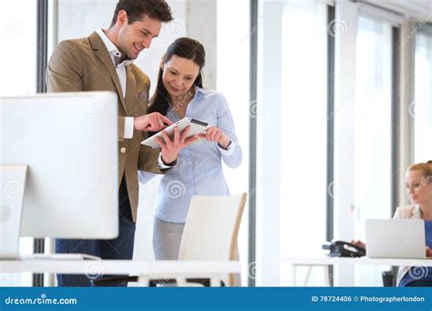Business People Using Tablet Computer With Female Colleague In