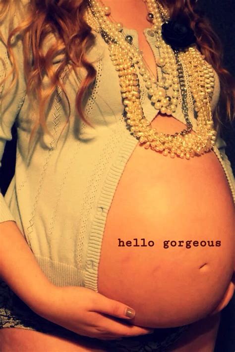 A Pregnant Woman With Her Belly Covered In Pearls And Necklaces Holding The Word Hello Gorgeous