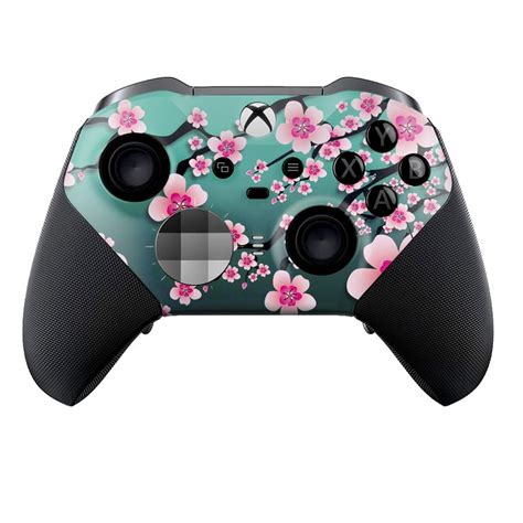 A Close Up Of A Controller On A White Background With Pink Flowers And