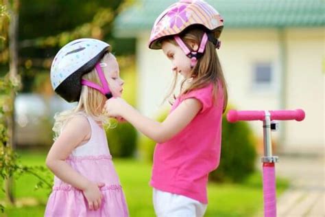 Little Girl Helping Her Sister To Put A Helmet On Coffee And Carpool