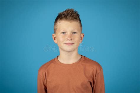 Closeup Portrait Of Smiling Preteen Boy Posing Over Blue Background