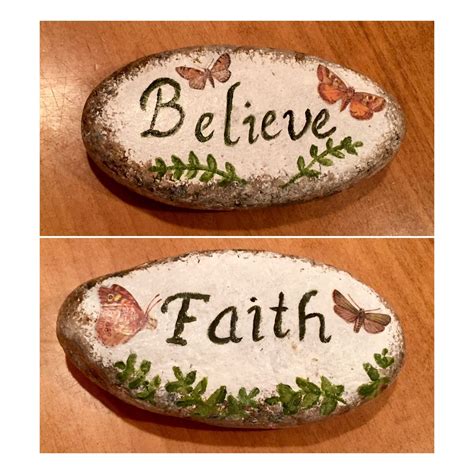 Two Rocks With The Words Believe Faith And Butterflies Painted On Each