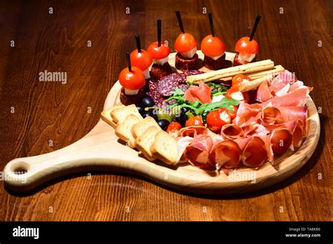 cold cut platter wooden platter with cold meat cuts and canape an oasis of pleasure stock