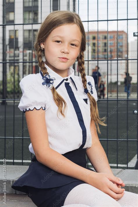Elementary Schoolgirl In Uniform At Playground Schoolgirl In A Darkly Blue Skirt And A White
