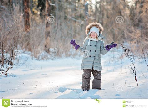 Cute Smiling Child Girl Standing In Snow In Winter Sunny