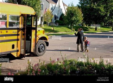 Mom Walking Son Across Street And Waving Goodbye To School Bus Driver St Paul Minnesota Mn Usa