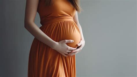 Premium Ai Image Pregnant Woman In Orange Dress Holding An Egg In Her