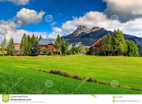 Stunning Green Field And Alpine Farm With Mountains