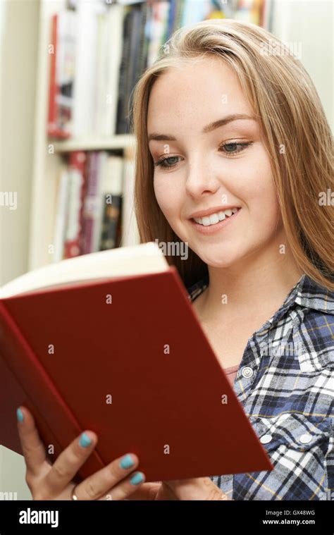 Teenage Girl Reading Book At Home Stock Photo Alamy