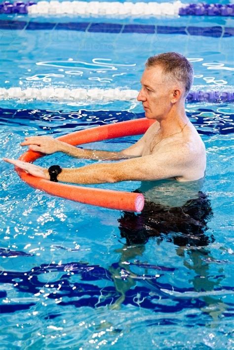 Image Of Hydrotherapy Physio Instructor In Pool With Noodle Austockphoto