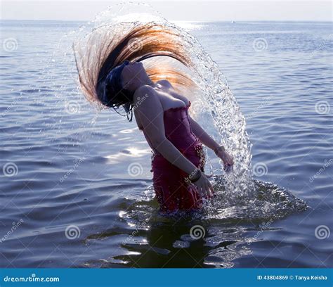 Young Woman Doing A Long Hair Of Water Splash In Sea Stock Photo