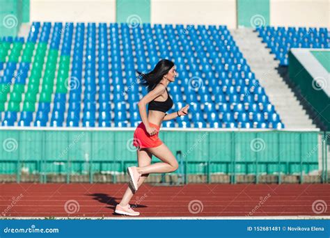 Girl Running Track On Stadium Real Side View Of Young Woman In Pink