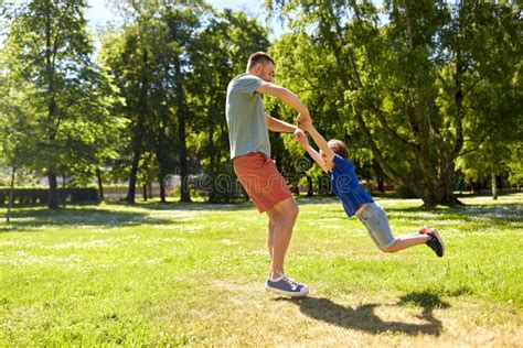 Padre Feliz E Hijo Hablando En El Parque De Verano Foto De Archivo