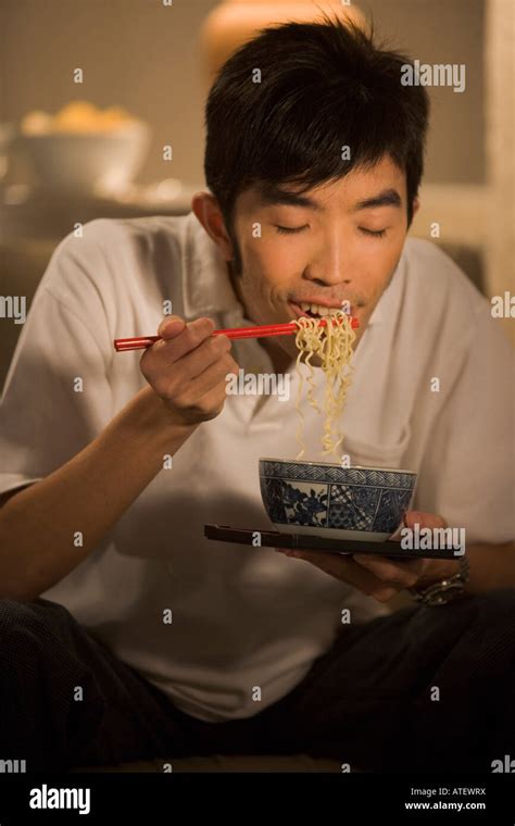 Young Man Eating Noodles Stock Photo Alamy