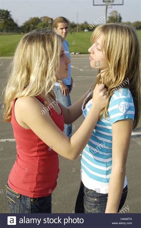 Two Young Women Standing In A Basketball Court Talking To Each Other