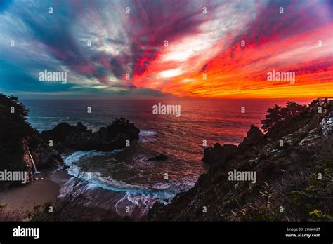 Fiery Sunset Over The Blue Waters Of Big Sur Ca At Mcway Falls Stock