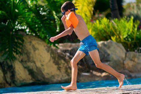 Boy Jumping In Outdoor Swimming Pool Boy Resting At Summer Resort By