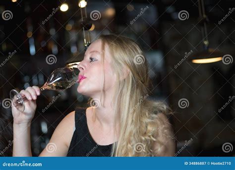 Beautiful Blond Woman Enjoying A Glass Of Champagne Or Prosecco Stock