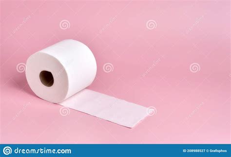 Roll Of White Toilet Paper Slightly Unrolled On A Plain Pink Background